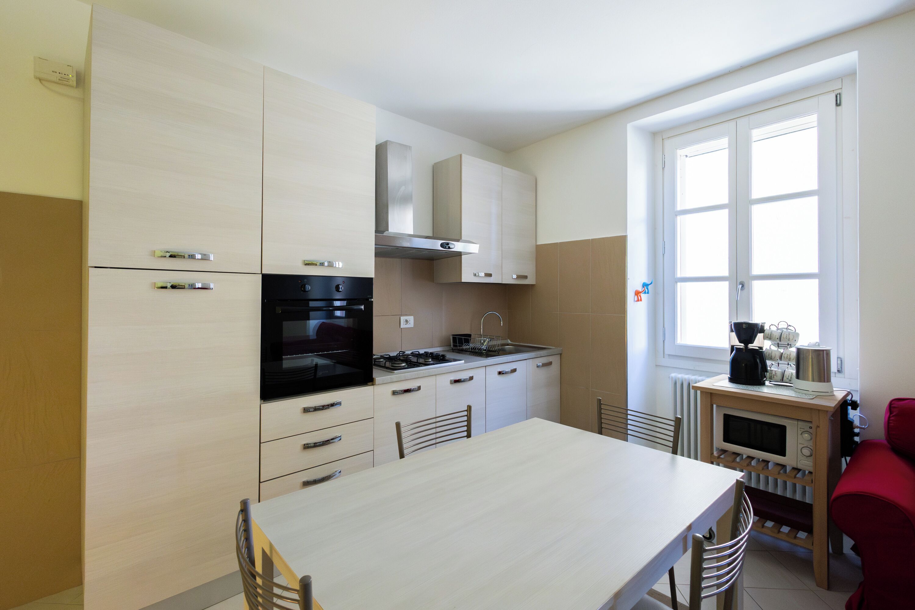 A modern kitchen with a dining table, chairs, a stove, oven, microwave, and cabinets.