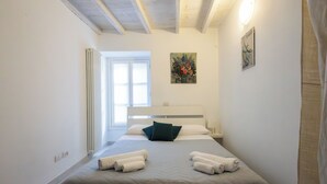 A bedroom with a bed, pillows, a painting, and a radiator. - Casa Rosa - hidden Garden with lake view (Fiumelatte)