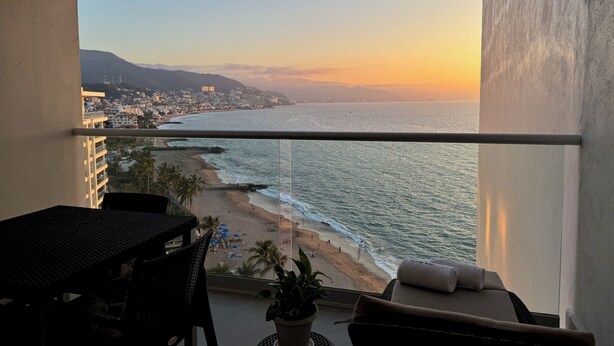 A balcony with a view of the beach and ocean at sunset. - Ocean view loft, Harbor 171 (Puerto Vallarta)