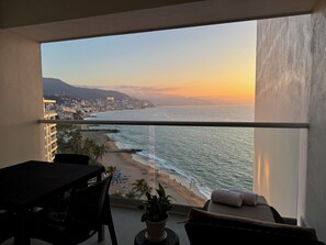 A balcony with a view of the beach and ocean at sunset. - Ocean view loft, Harbor 171 (Puerto Vallarta)