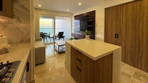 A modern kitchen with a central island, a dining area with a view, and a large wooden wardrobe. - Ocean view loft, Harbor 171 (Puerto Vallarta)