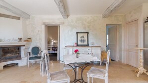 Un comedor con chimenea, una mesa con sillas y un cuadro en la pared.