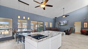 Een moderne keuken met een groot eiland, ingebouwde apparatuur en een eethoek met uitzicht.