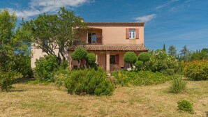A two-story house with a tiled roof, surrounded by greenery and trees. - Holiday Home 'Lacoste Home' with Mountain View, Shared Pool and Wi-Fi (Lacoste)