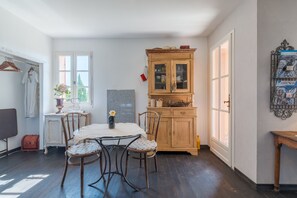 A dining area with a table, chairs, a cabinet, and a wall-mounted display. - Holiday Home 'Lacoste Home' with Mountain View, Shared Pool and Wi-Fi (Lacoste)