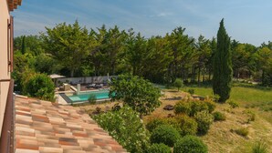 A residential area with a swimming pool, lush greenery, and a tiled roof. - Holiday Home 'Lacoste Home' with Mountain View, Shared Pool and Wi-Fi (Lacoste)