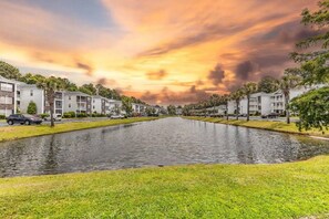 Un quartier résidentiel avec un canal, des immeubles d’appartements et des voitures garées.