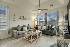 Un salon spacieux avec deux canapés, une table basse et un téléviseur.