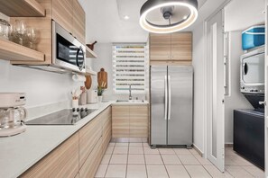 A modern kitchen with a built-in oven, a stainless steel refrigerator, and a coffee machine. - Modern Chic Retreat | Near Ferry & Beach | Pool (Ceiba)