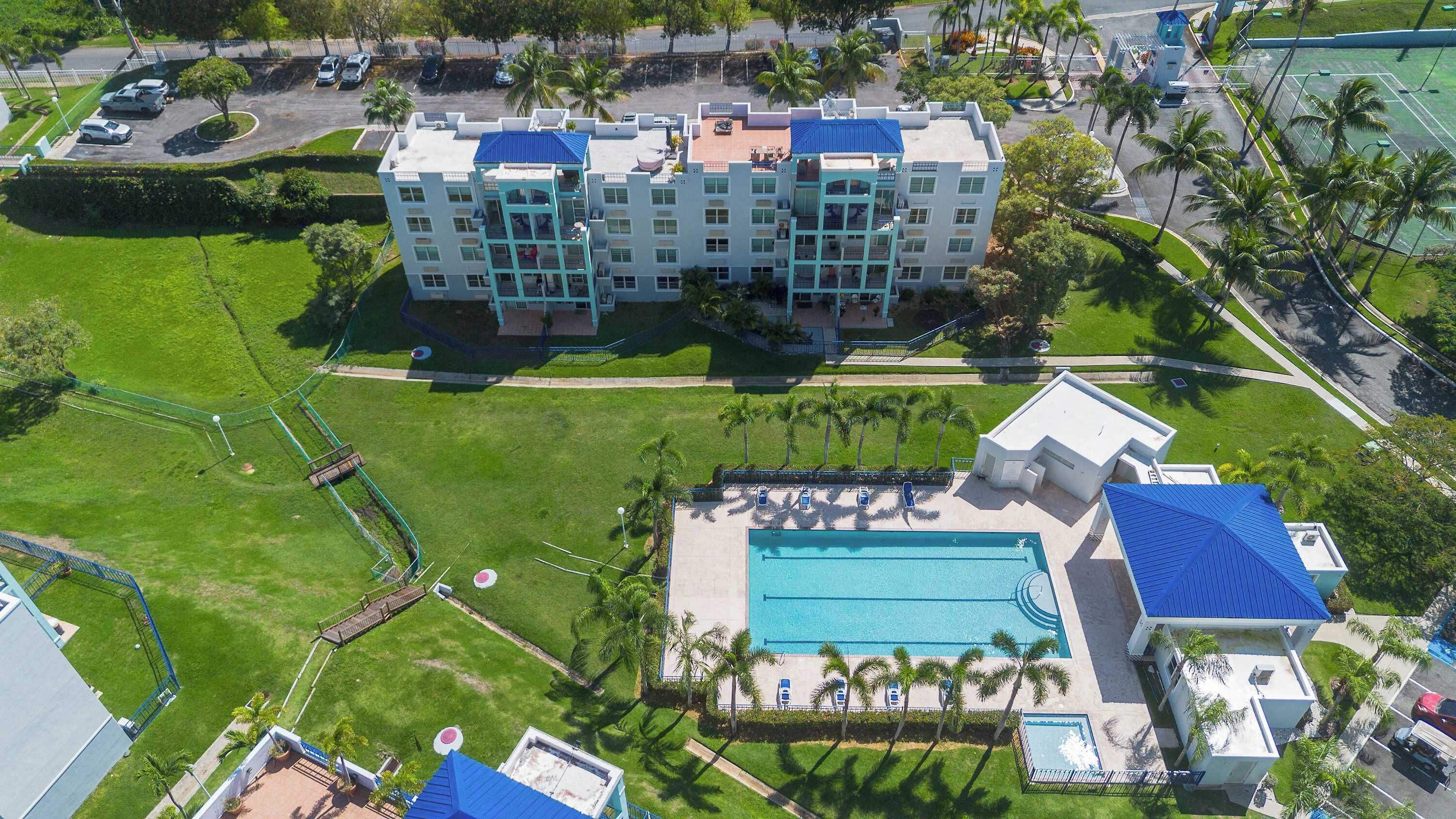 Ein mehrstöckiges Hotel mit Schwimmbad und Tennisplatz.