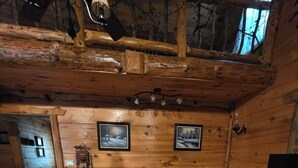 L’intérieur d’un chalet confortable, avec un ensemble de canapés, un téléviseur et une cheminée.