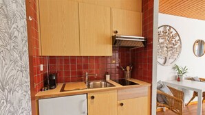 Une cuisine compacte avec des meubles en bois, un évier en acier inoxydable et un petit plan de travail.