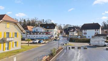 Una calle residencial con casas, coches aparcados y una caravana.