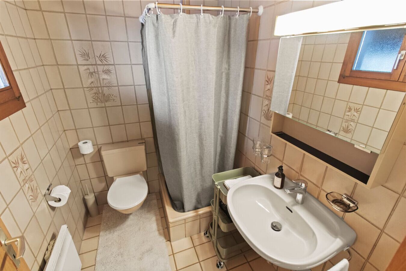 Une salle de bain avec des toilettes, un lavabo et un rideau de douche.