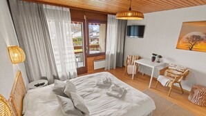 Un dormitorio con una cama grande, un escritorio y una silla.