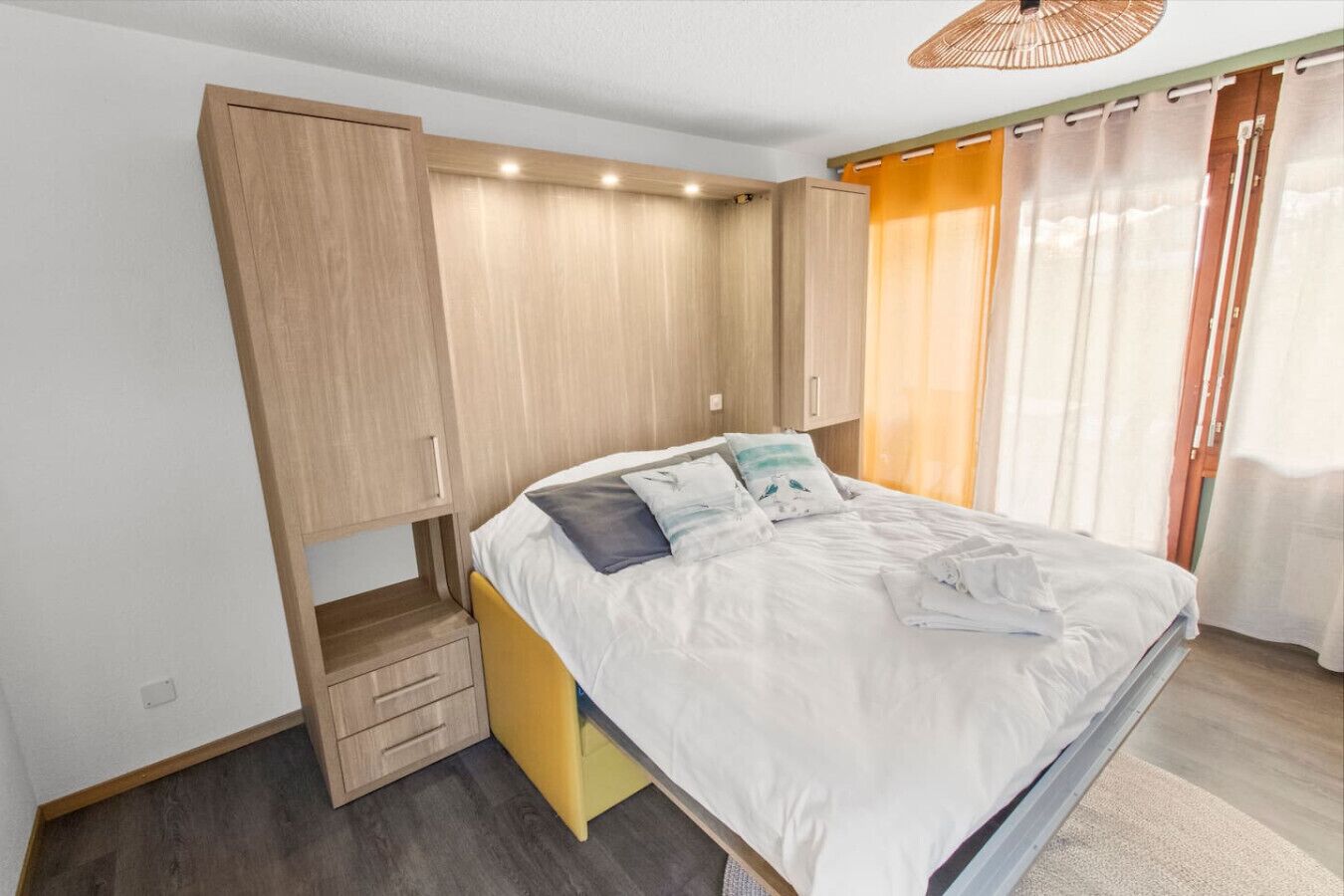 Une chambre à coucher avec un lit, une armoire et un petit meuble.