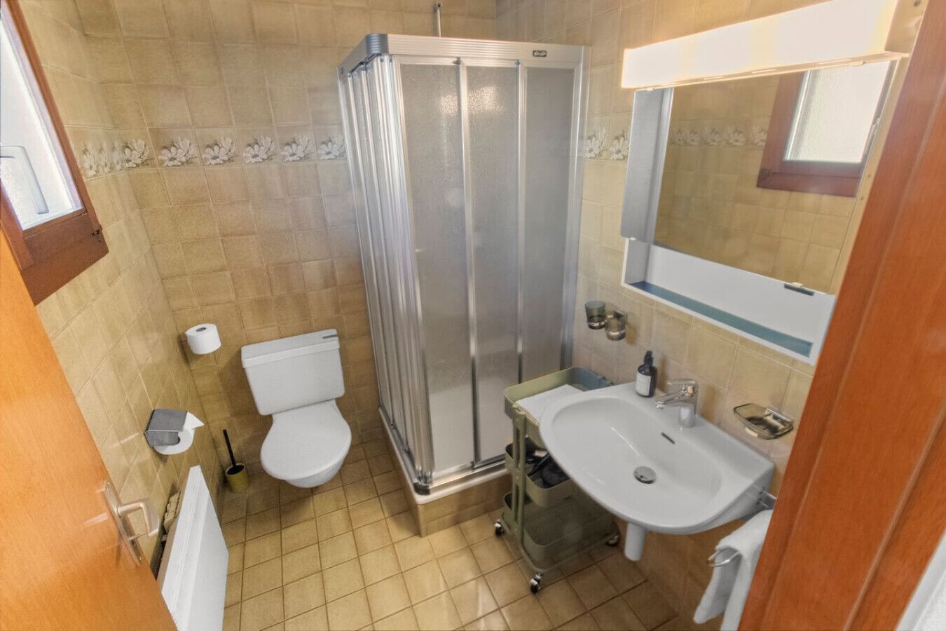 Une salle de bain avec douche, toilettes et lavabo.