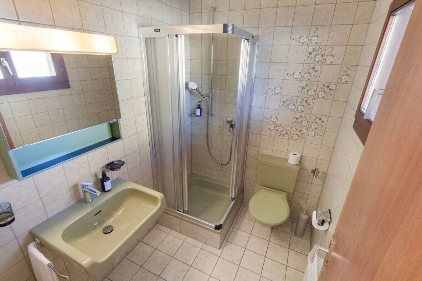 Kylpyhuone, jossa on suihkukaappi, pesuallas ja wc.