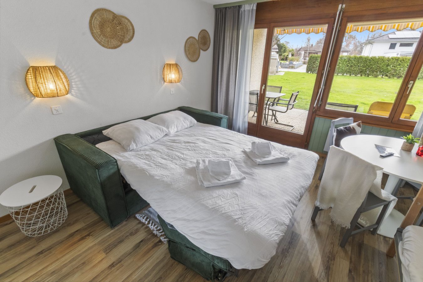 Une chambre bien rangée, avec un lit, des tables de chevet et une vue sur l’extérieur.