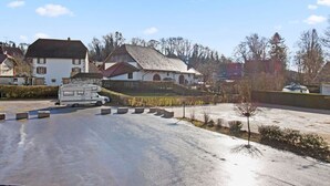 Ett bostadsområde med hus, en parkerad husbil och en väg med en kurva.