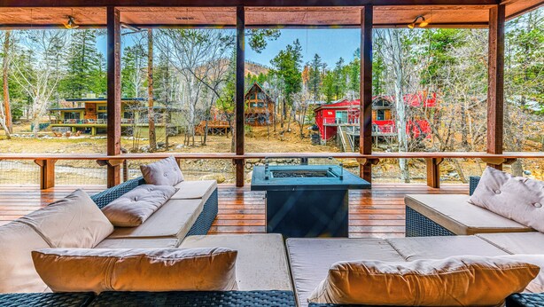 A wooden deck with outdoor seating and a fire pit.