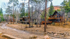 A lodge with a wooden exterior, multiple decks, and a stone pathway leading to the entrance.