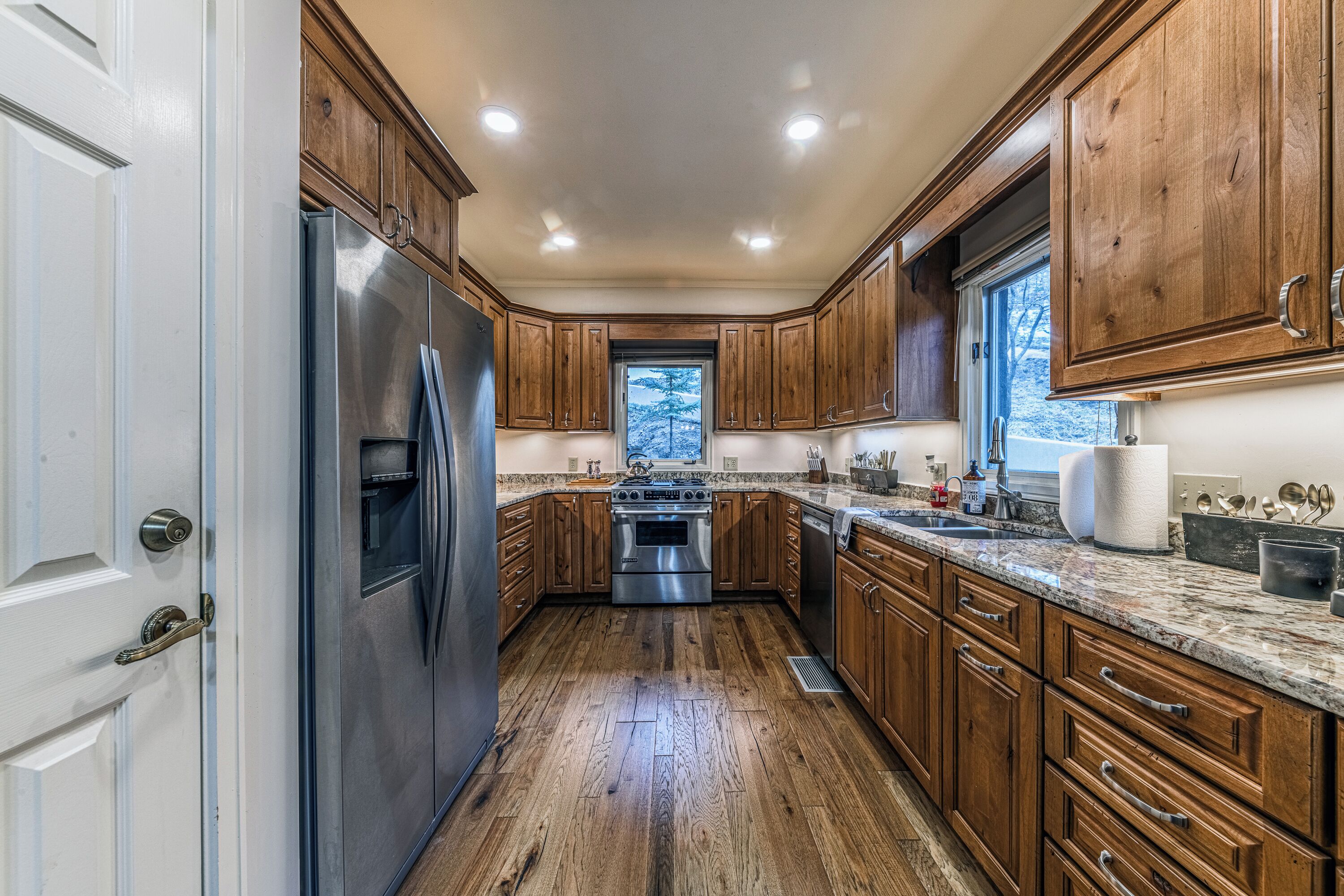 A kitchen with wooden cabinets, stainless steel appliances, and a granite countertop.