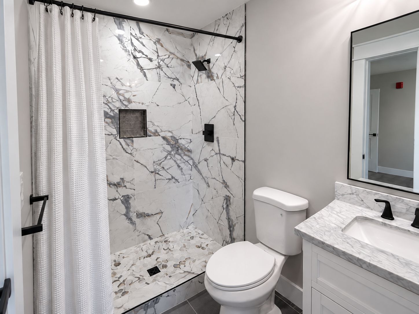 Een badkamer met douche, toilet en wastafel.