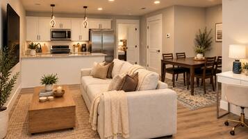 A modern living room with a sofa, coffee table, and dining area.