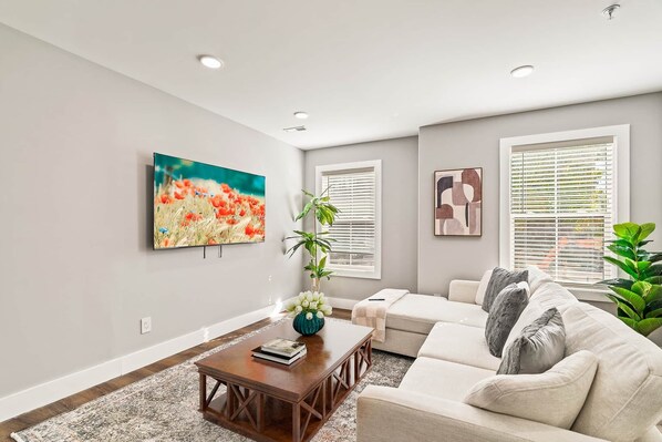 A modern living room with a sofa, coffee table, and artwork on the walls.