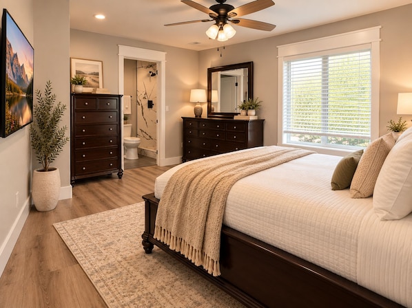 A bedroom with a bed, dresser, and a ceiling fan.