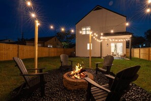 A backyard with a fire pit, outdoor seating, and string lights. - Arches on Decatur (2mi to Downtown & UT, King Bed) (Knoxville)
