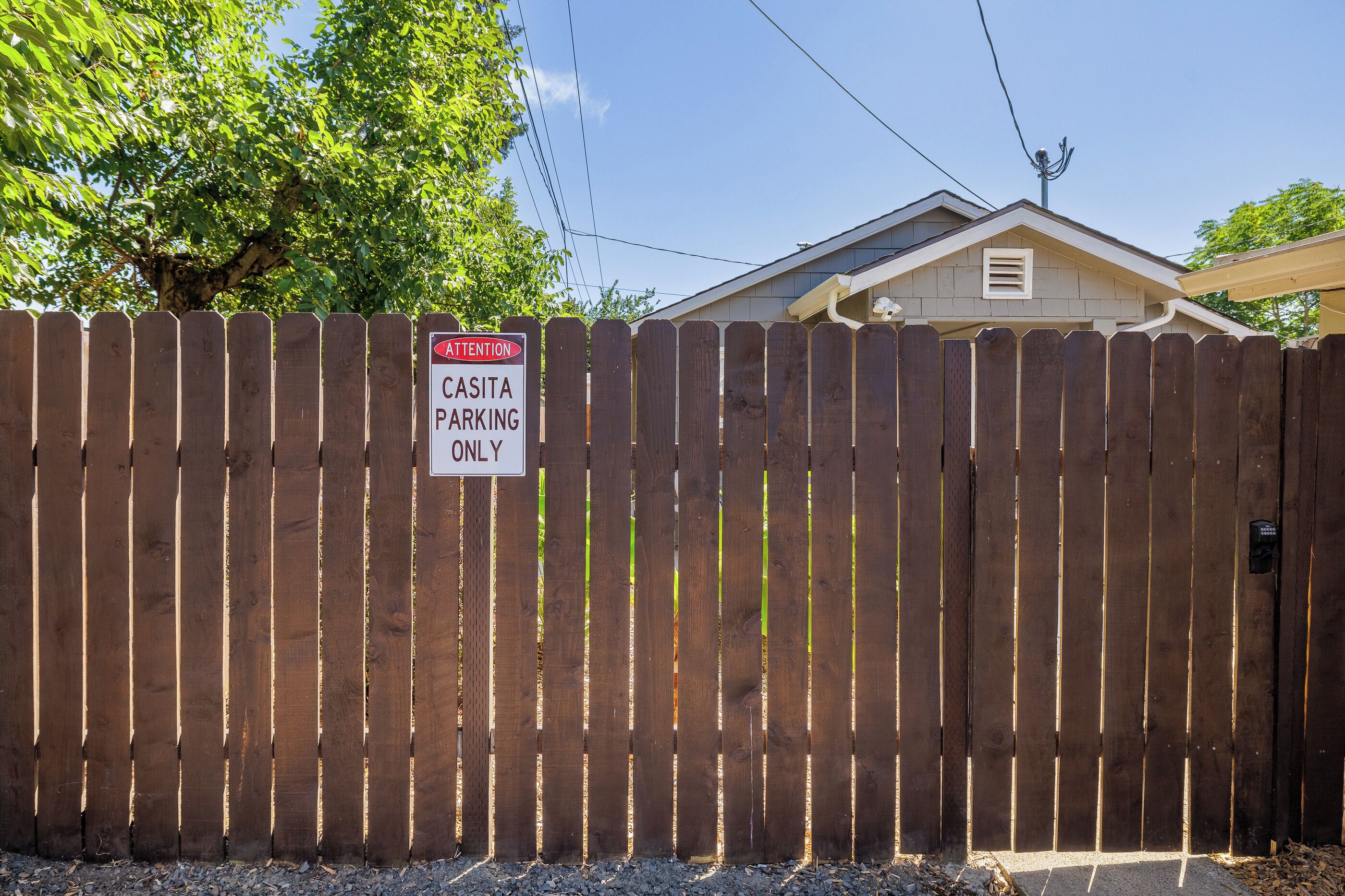 A wooden fence with a sign indicating 'CASITA PARKING ONLY.'
