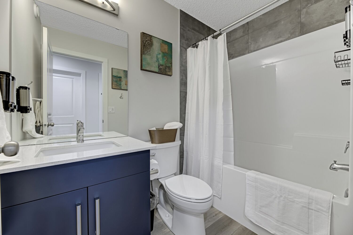 A modern bathroom with a white sink, a toilet, and a shower area.
