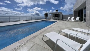 A rooftop pool area with a clear view of the ocean, a covered seating area, and lounge chairs. - Villa Vista Atl Ntica by Atlantic Holiday (Ribeira Brava)