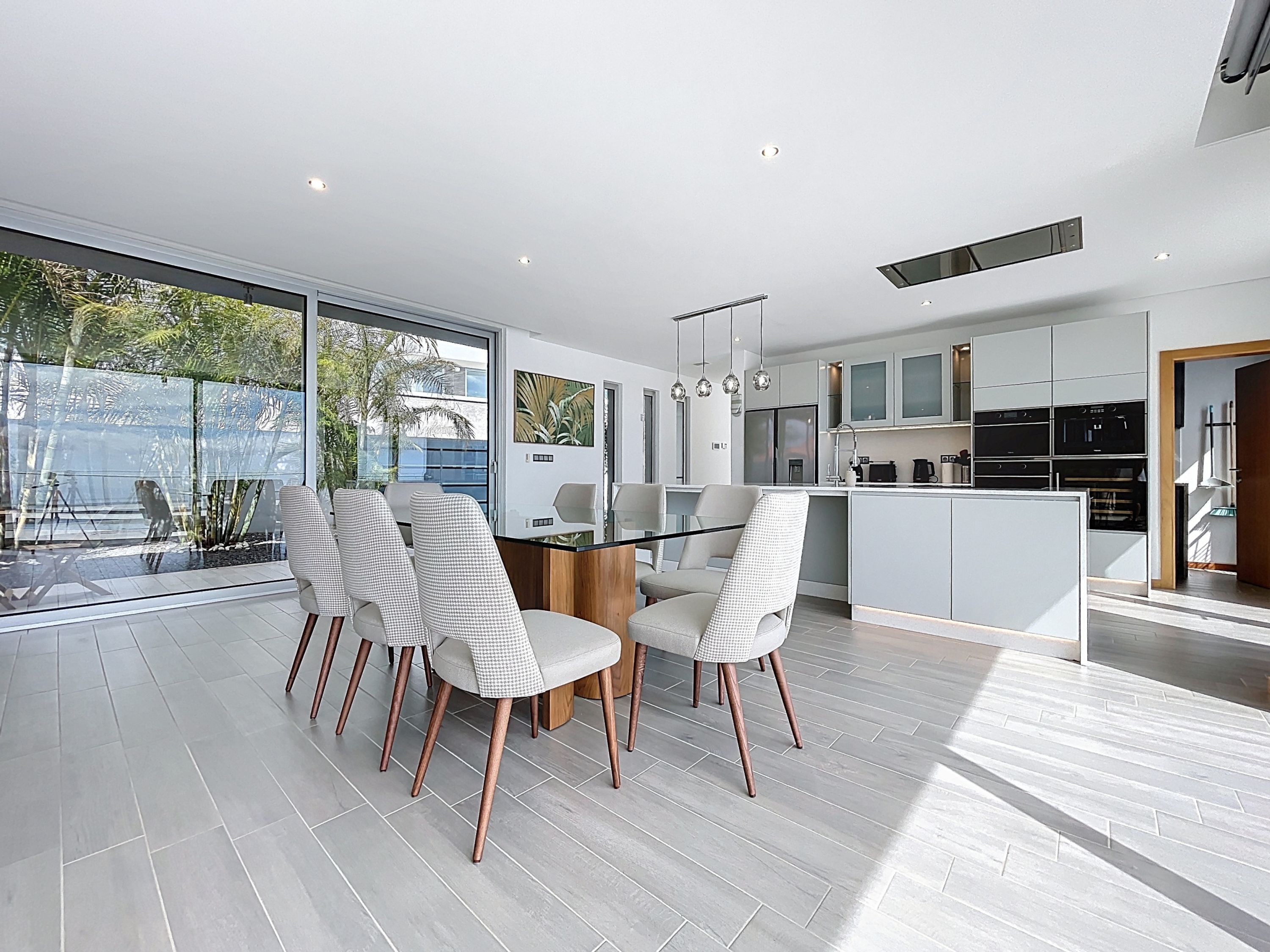 A modern kitchen with white cabinets, a central island, and stainless steel appliances.
