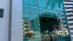 Un edificio moderno con una vasta facciata in vetro e un cartello che riporta la scritta "Aquamarine Hotel".