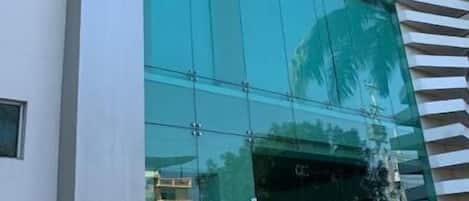 Um edifício moderno com fachada de vidro ampla e uma placa que diz 'Aquamarine Hotel'.