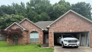 A brick house with a garage, a driveway, and a tree in the front yard. - Peaceful 3-bedroom house with garage and AC in a charming subdivision in Benton. (Benton)