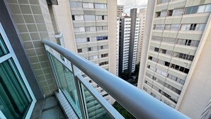 Un edificio residencial alto con varios balcones y baranda metálica.