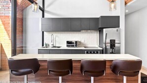 A modern kitchen with a central island, dark cabinets, and stainless steel appliances. - Perfect 2-bedroom condo Casa Arte with AC in Puerto Vallarta (Puerto Vallarta)