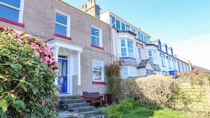 A row of terraced houses with a front garden, steps, and a bench. - Garth Celyn (Porthmadog)
