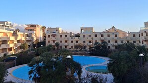 A residential building complex with multiple balconies, a swimming pool, and surrounding greenery. - Beachfront with pool Eucalyptus garden (Alghero)