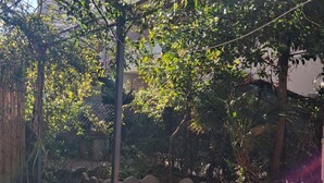 A courtyard with a pergola, tiled flooring, and surrounding greenery. - Beachfront with pool Eucalyptus garden (Alghero)