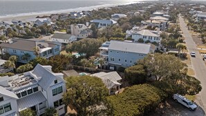 An aerial view of a coastal residential area with houses, a beach, and a clear sky. - Camp Carolina 3BR 2BA home with private pool close to beach! (Isle Of Palms)
