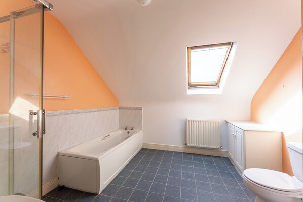 A bathroom with a bathtub, toilet, and shower. - Ballyneill Farmhouse (Mullagh)