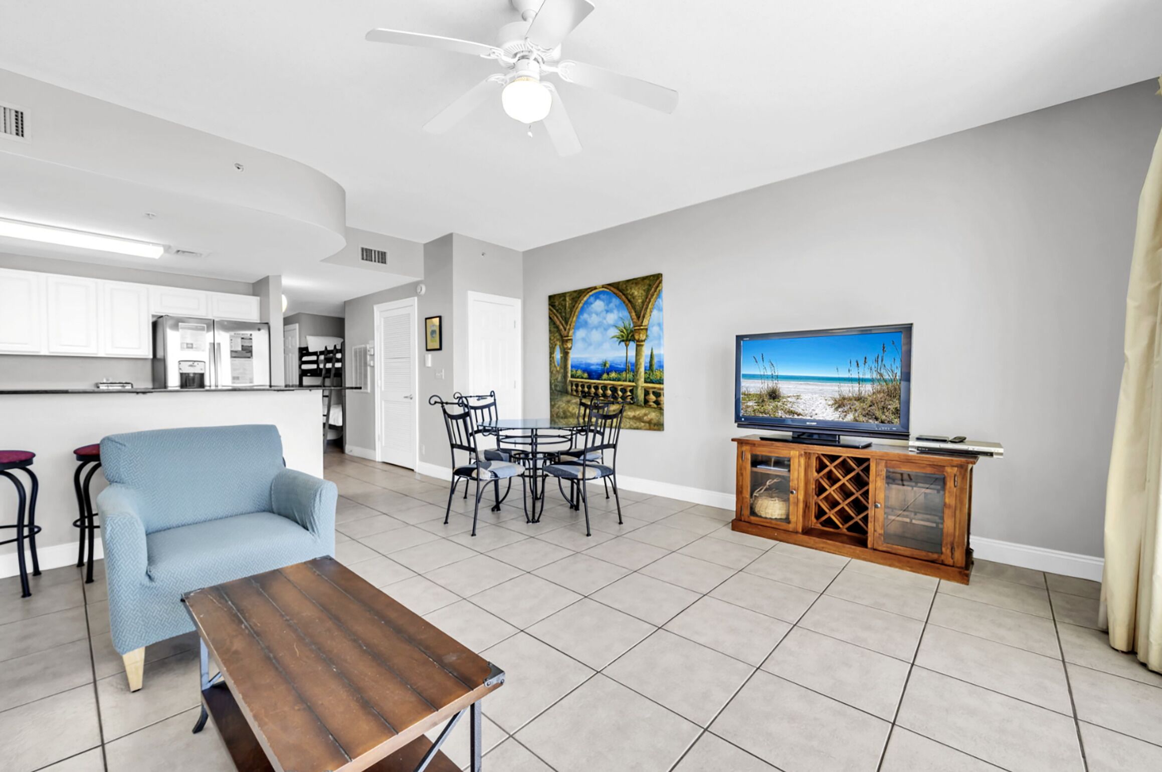 A living room with a sofa, coffee table, TV, and artwork on the wall.
