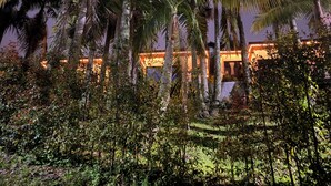 A building with a warm-lit facade, surrounded by dense tropical vegetation. - La Escondida Finca Hotel 12 minutes from the airport int JMC rionegro(MEDELLIN) (Guarne)