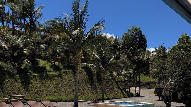 A swimming pool with a tiled edge, a metal handrail, and a picnic table. - La Escondida Finca Hotel 12 minutes from the airport int JMC rionegro(MEDELLIN) (Guarne)