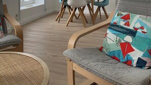 Una sala de estar moderna con un sofá, una mesa redonda y un comedor con sillas y una mesa.